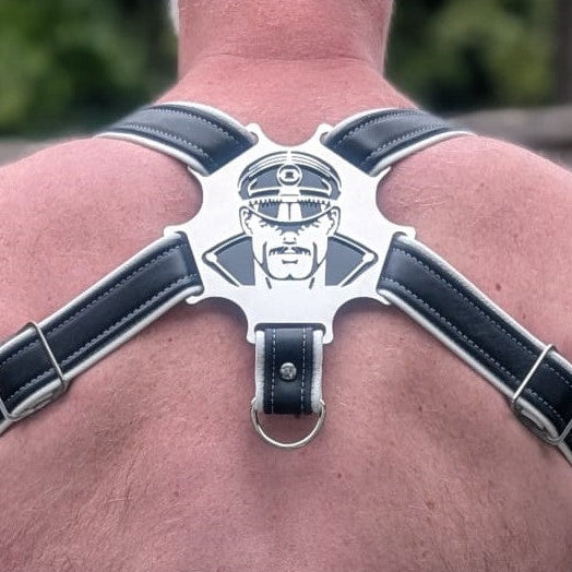 Person wearing a black leather harness with a central emblem on their back.
